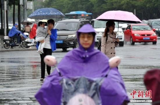 市民在雨中出行。張斌 攝