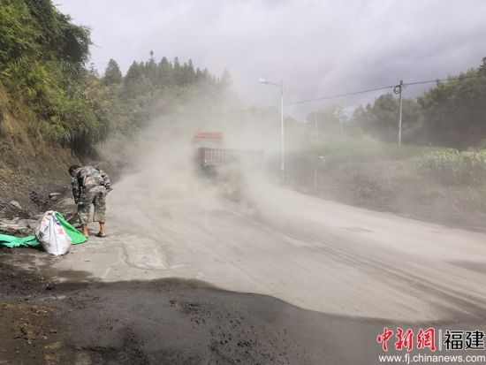 不斷行經(jīng)該路段的車輛揚起一陣陣水泥粉灰，因而產(chǎn)生“霧霾”效果。余思煥 攝