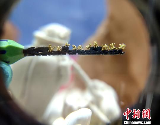 圖為臺灣微雕藝術(shù)家陳逢顯的作品“黃金小老鼠”?！蚊?攝