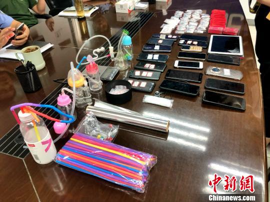 圖為警方繳獲的吸毒工具、作案手機及毒品等?！∠默?攝