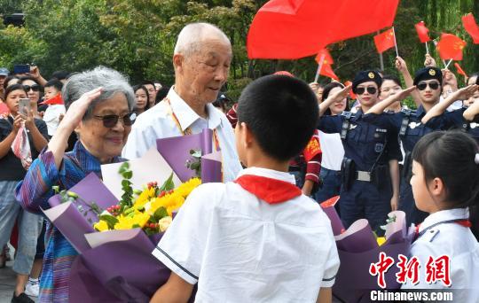 小學生向離休干部獻上鮮花?！堃?攝