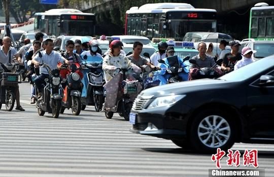 10月10日，福州街頭，民眾騎著電動(dòng)自行車出行。中新社記者 張斌 攝