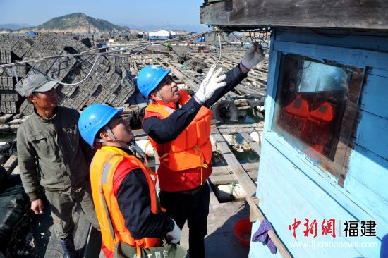 圖為1月8日，連江縣供電公司服務(wù)隊隊員在漁排上為漁民用電線路進行巡查，消除潛在的安全隱患，確保漁民們在春節(jié)期間生產(chǎn)和生活用電安全。