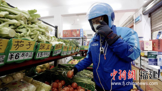 外賣小哥一邊手持電話溝通，一邊裝揀貨品